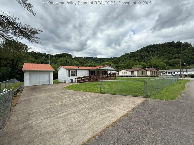 12 Brewster Dr, Chapmanville, WV 25508 - view of front of home with an outbuilding, driveway, a view of trees, metal roof, and a detached garage