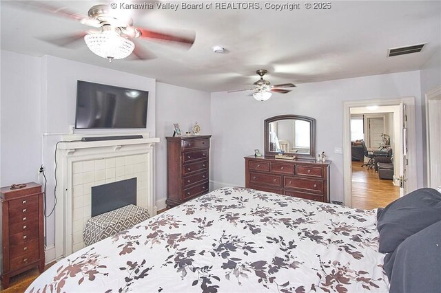 1313 Lee St E Unit 231, Charleston, WV 25301 - bedroom with wood finished floors, ceiling fan, and a tile fireplace