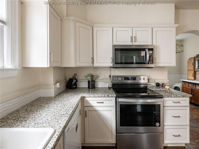 657 Beech Ave, Charleston, WV 25302 - kitchen featuring stainless steel appliances, light stone countertops, white cabinetry, and arched walkways