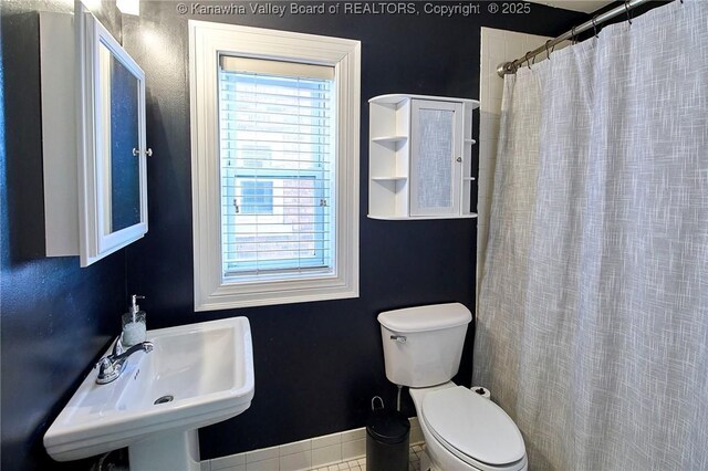 1313 Lee St E Unit 233, Charleston, WV 25301 - full bath featuring toilet, a sink, baseboards, and curtained shower