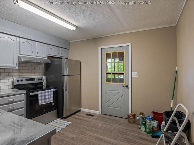 67 Poplar Dr, Scott Depot, WV 25560 - kitchen with stainless steel appliances, under cabinet range hood, wood finished floors, decorative backsplash, and a textured ceiling