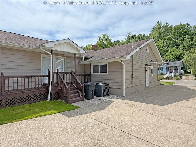 2111 21st St, Nitro, WV 25143 - view of front of property featuring central air condition unit, concrete driveway, a chimney, and a shingled roof