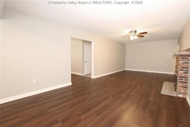2111 21st St, Nitro, WV 25143 - unfurnished living room featuring ceiling fan, dark wood-type flooring, baseboards, and a brick fireplace