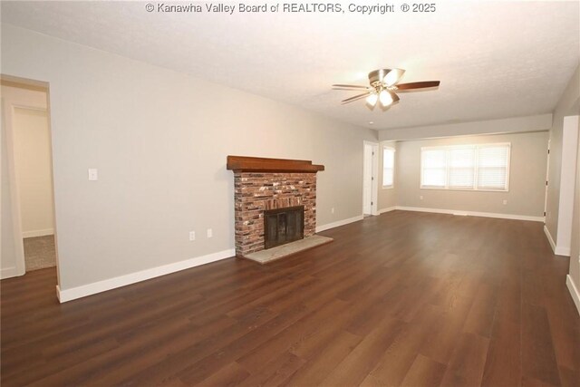 2111 21st St, Nitro, WV 25143 - unfurnished living room featuring ceiling fan, dark wood finished floors, a brick fireplace, and baseboards