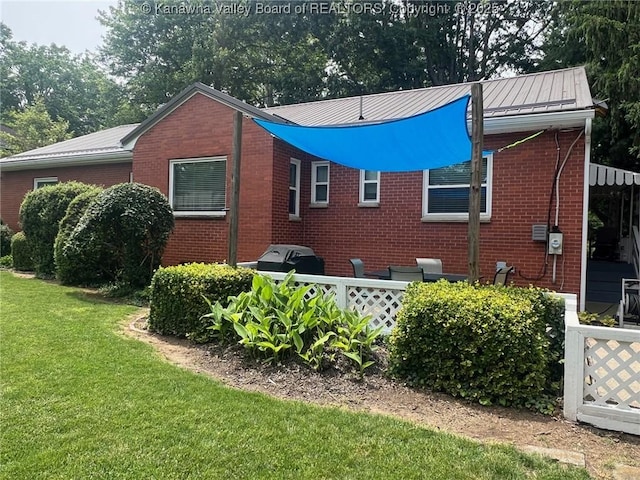 814 Skinner Dr, Saint Albans, WV 25177 - view of home's exterior featuring brick siding, a lawn, and metal roof
