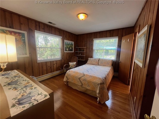 814 Skinner Dr, Saint Albans, WV 25177 - bedroom with wooden walls, a baseboard radiator, wood finished floors, baseboard heating, and baseboards