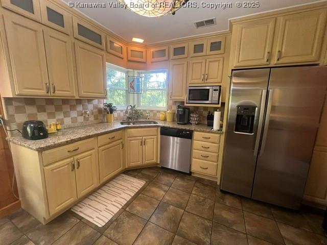 814 Skinner Dr, Saint Albans, WV 25177 - kitchen with stainless steel appliances, a sink, decorative backsplash, light stone countertops, and glass insert cabinets