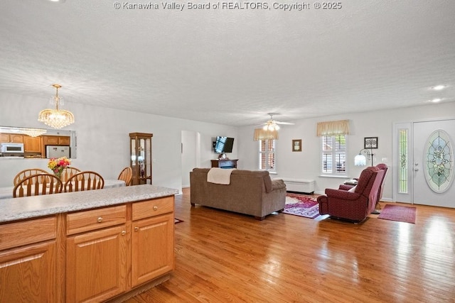 108 Lock Ln, Alum Creek, WV 25003 - living room featuring a chandelier, light wood-type flooring, a textured ceiling, and a ceiling fan