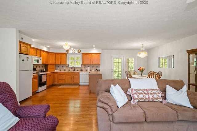 108 Lock Ln, Alum Creek, WV 25003 - living room with light wood-type flooring, a textured ceiling, and a chandelier