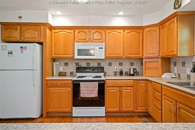 108 Lock Ln, Alum Creek, WV 25003 - kitchen with white appliances, a sink, light wood finished floors, light countertops, and tasteful backsplash