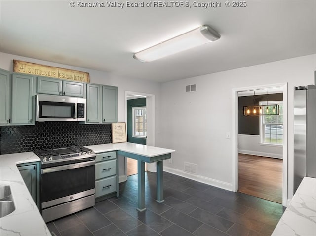 1300 Enslow Blvd, Huntington, WV 25701 - kitchen featuring appliances with stainless steel finishes, decorative backsplash, light stone counters, and healthy amount of natural light