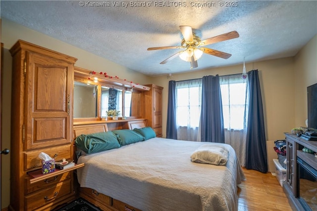 400 13th St, Dunbar, WV 25064 - bedroom featuring a textured ceiling, light wood-style flooring, and ceiling fan
