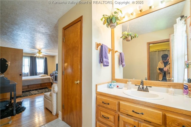 400 13th St, Dunbar, WV 25064 - full bathroom with a textured ceiling, vanity, ensuite bathroom, hardwood / wood-style flooring, and a ceiling fan