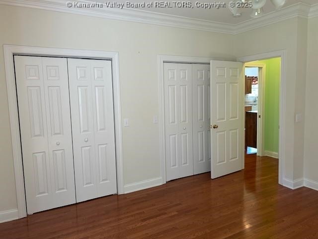 8 Dapplewood Rd, South Charleston, WV 25309 - unfurnished bedroom featuring multiple closets, crown molding, baseboards, and wood finished floors