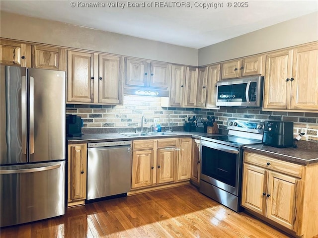 237 Pine Cir, Dunbar, WV 25064 - kitchen with stainless steel appliances, a sink, dark countertops, tasteful backsplash, and wood finished floors