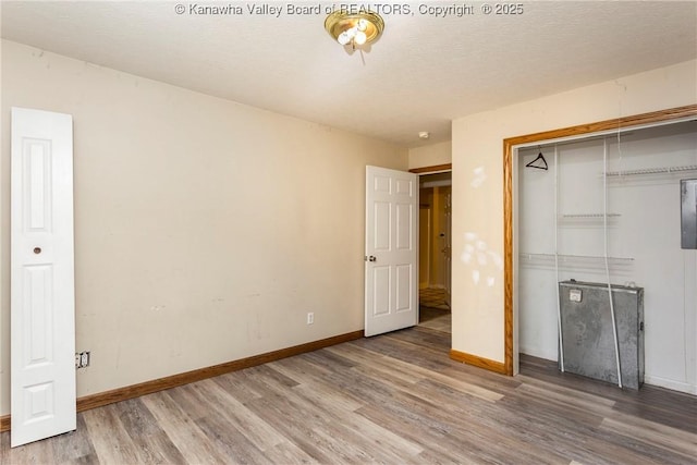 4096 Indian Creek Rd, Elkview, WV 25071 - unfurnished bedroom with wood finished floors, baseboards, a closet, and a textured ceiling