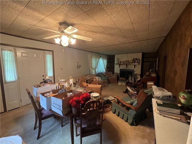 7966 Deepwater Mountain Rd, Kincaid, WV 25119 - dining room featuring a ceiling fan, concrete flooring, and a fireplace