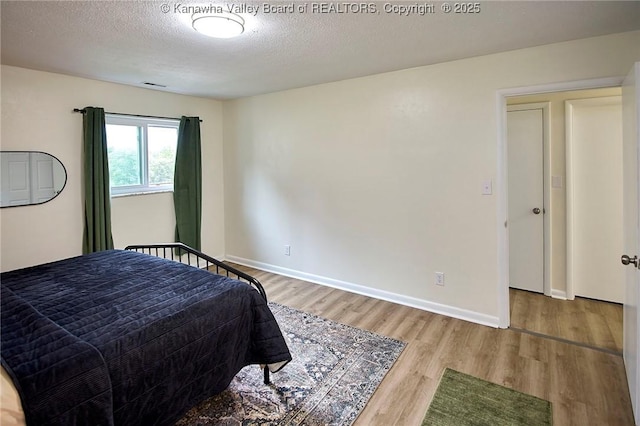 5201 Hammons Dr, Charleston, WV 25313 - bedroom with wood finished floors, a textured ceiling, and baseboards