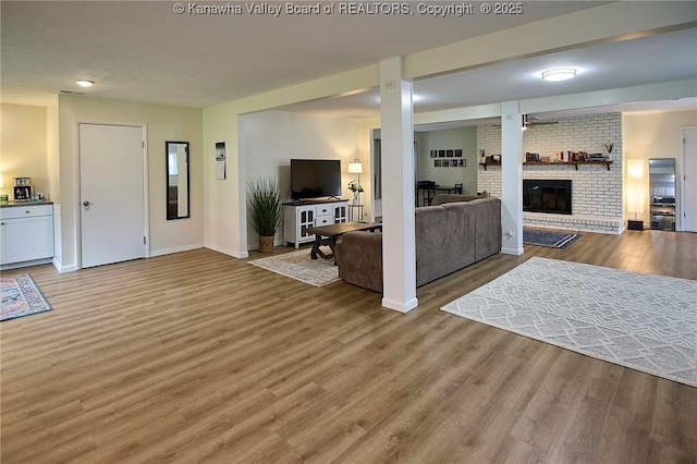 5201 Hammons Dr, Charleston, WV 25313 - living area featuring a brick fireplace, light wood-style flooring, and baseboards