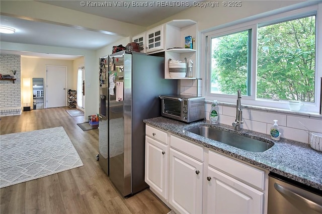 5201 Hammons Dr, Charleston, WV 25313 - kitchen with a sink, stainless steel appliances, light wood-type flooring, tasteful backsplash, and white cabinets