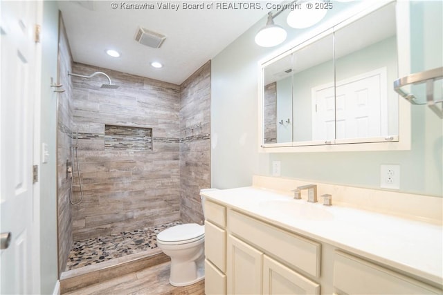 102 Utah Hollow Rd, Charleston, WV 25312 - bathroom featuring vanity, wood finished floors, toilet, tiled shower, and recessed lighting