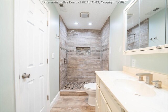 102 Utah Hollow Rd, Charleston, WV 25312 - full bath with vanity, toilet, a tile shower, wood finished floors, and recessed lighting