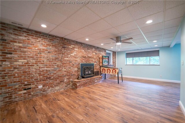 102 Utah Hollow Rd, Charleston, WV 25312 - living area featuring a wood stove, baseboards, wood finished floors, a paneled ceiling, and a ceiling fan