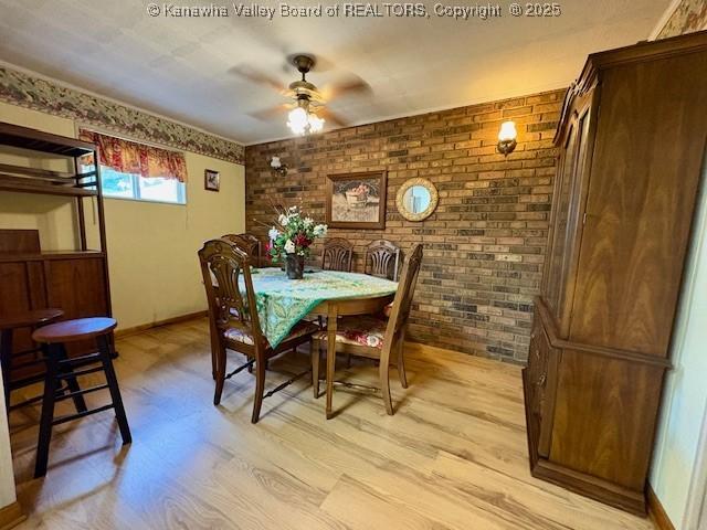 2011 Archibald Dr, Charleston, WV 25320 - dining room featuring brick wall, light wood-type flooring, a ceiling fan, and baseboards