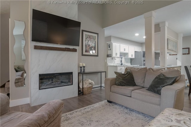 26 Banister Dr, Cross Lanes, WV 25313 - living area featuring wood finished floors, baseboards, decorative columns, a glass covered fireplace, and recessed lighting