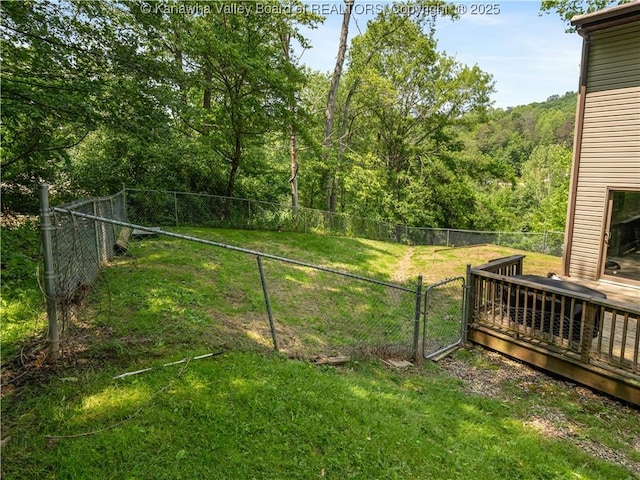 26 Banister Dr, Cross Lanes, WV 25313 - view of yard featuring a wooden deck, a gate, and a forest view