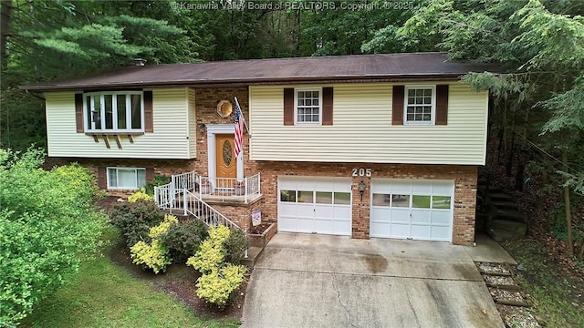 205 Autumn Dr, Dunbar, WV 25064 - split foyer home featuring an attached garage, concrete driveway, and brick siding