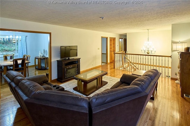 205 Autumn Dr, Dunbar, WV 25064 - living area with a chandelier, hardwood / wood-style flooring, baseboards, and a textured ceiling