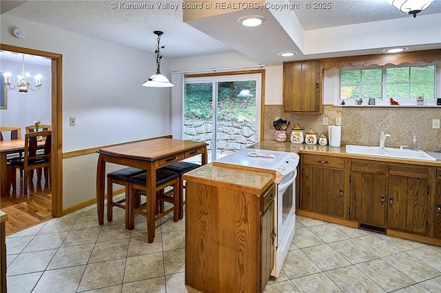 205 Autumn Dr, Dunbar, WV 25064 - kitchen featuring a sink, white electric range oven, brown cabinets, light tile patterned floors, and tasteful backsplash