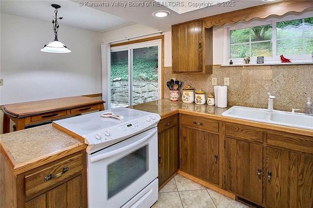 205 Autumn Dr, Dunbar, WV 25064 - kitchen with white range with electric cooktop, a sink, a peninsula, brown cabinetry, and tasteful backsplash