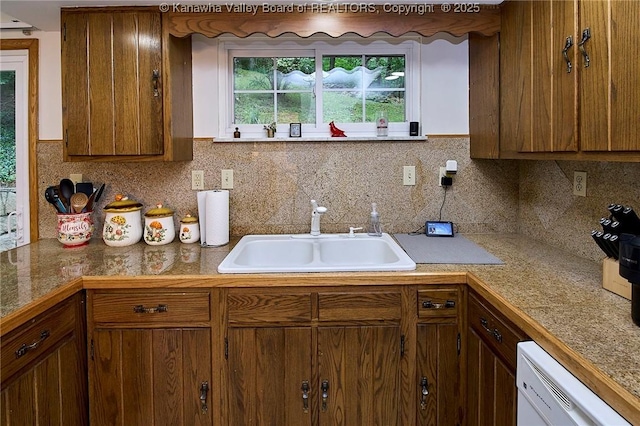 205 Autumn Dr, Dunbar, WV 25064 - kitchen with a sink, white dishwasher, brown cabinetry, and tasteful backsplash