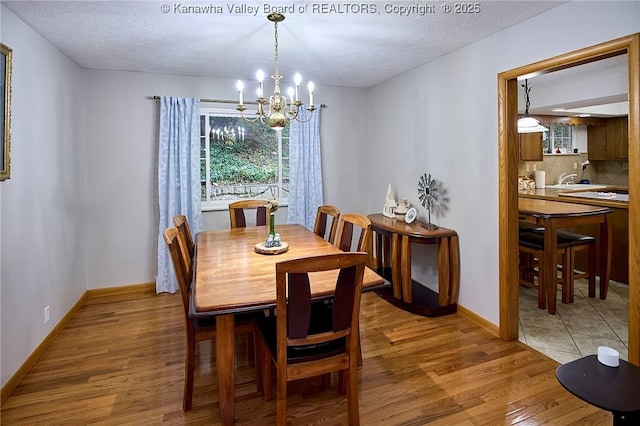 205 Autumn Dr, Dunbar, WV 25064 - dining area with a chandelier, light wood finished floors, a textured ceiling, and baseboards