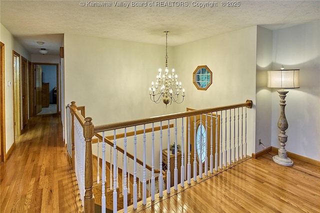 205 Autumn Dr, Dunbar, WV 25064 - corridor featuring an upstairs landing, wood finished floors, a textured ceiling, baseboards, and a chandelier