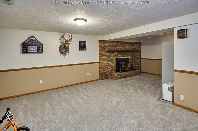 205 Autumn Dr, Dunbar, WV 25064 - unfurnished living room featuring carpet floors, a wood stove, a textured ceiling, and baseboards
