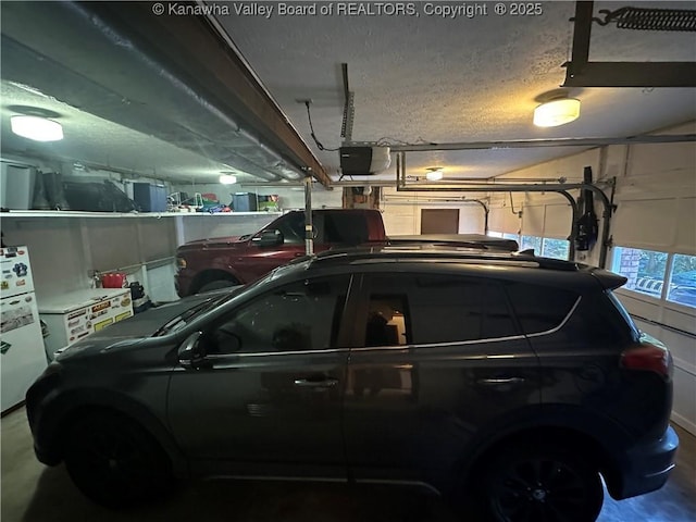 205 Autumn Dr, Dunbar, WV 25064 - garage featuring a garage door opener and freestanding refrigerator