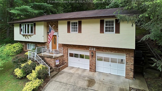 205 Autumn Dr, Dunbar, WV 25064 - raised ranch featuring a garage, driveway, and brick siding