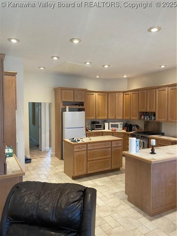 11 Larabee Ln, Winfield, WV 25213 - kitchen featuring a center island, freestanding refrigerator, recessed lighting, high end range, and brown cabinetry