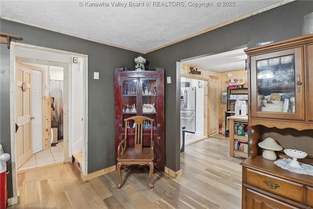 223 Easter Rd, Nitro, WV 25143 - dining room featuring light wood-type flooring, a textured ceiling, and baseboards