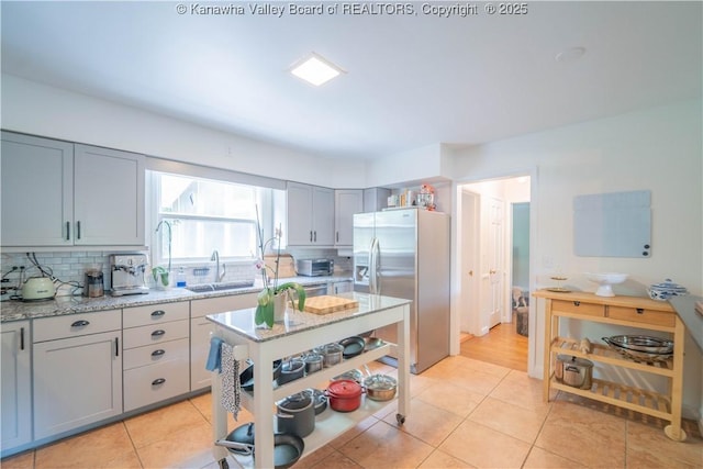 1418 Sweetbrier Rd, Charleston, WV 25314 - kitchen featuring stainless steel fridge with ice dispenser, tasteful backsplash, gray cabinets, a sink, and light stone countertops
