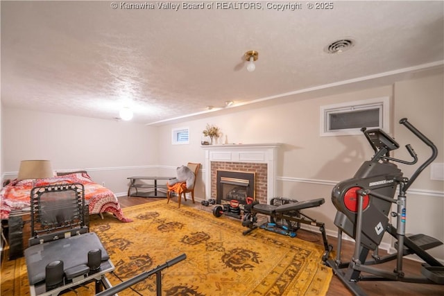 1418 Sweetbrier Rd, Charleston, WV 25314 - exercise area featuring wood finished floors, baseboards, a brick fireplace, and a textured ceiling