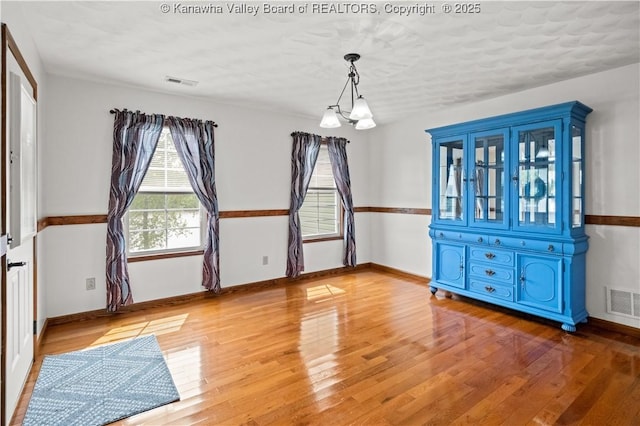 213 Rumer Sta, Red House, WV 25168 - unfurnished dining area with wood finished floors, a chandelier, and baseboards