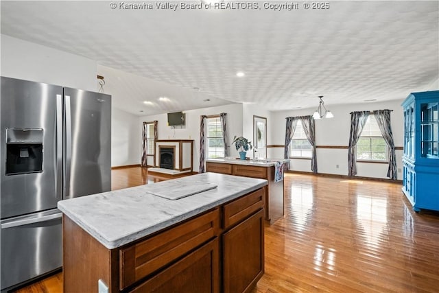 213 Rumer Sta, Red House, WV 25168 - kitchen featuring stainless steel fridge with ice dispenser, a kitchen island, open floor plan, light countertops, and light wood-style flooring