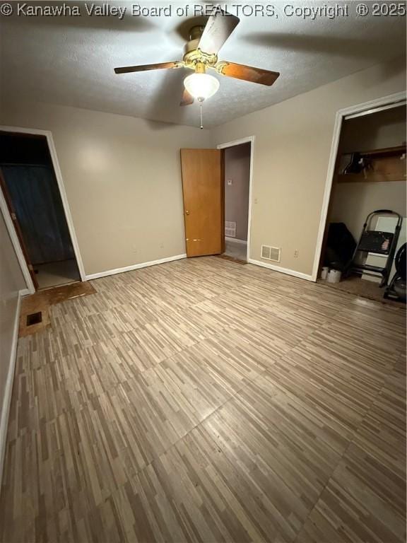 211 Geronimo Dr, Saint Albans, WV 25177 - unfurnished bedroom with baseboards, wood finished floors, a closet, a textured ceiling, and a ceiling fan