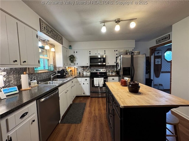 3902 Poca River Rd S, Poca, WV 25159 - kitchen with appliances with stainless steel finishes, butcher block countertops, dark wood-style floors, white cabinetry, and tasteful backsplash
