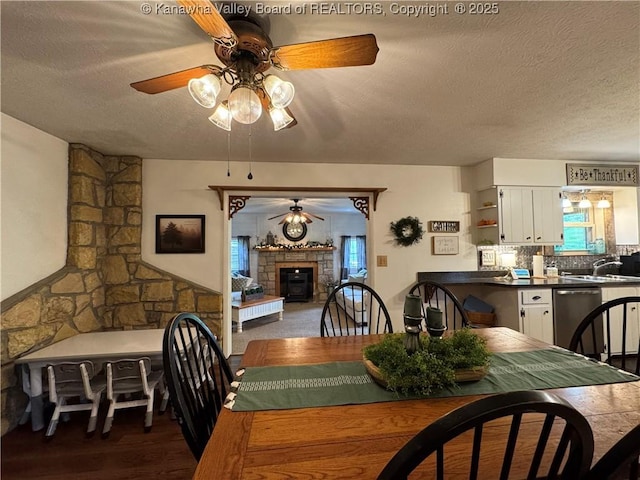 3902 Poca River Rd S, Poca, WV 25159 - dining area with a ceiling fan, a textured ceiling, a fireplace, and wood finished floors