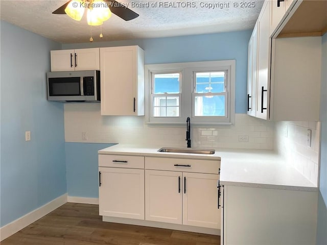 517 16th St, Dunbar, WV 25064 - kitchen featuring stainless steel microwave, a sink, a textured ceiling, a ceiling fan, and white cabinets